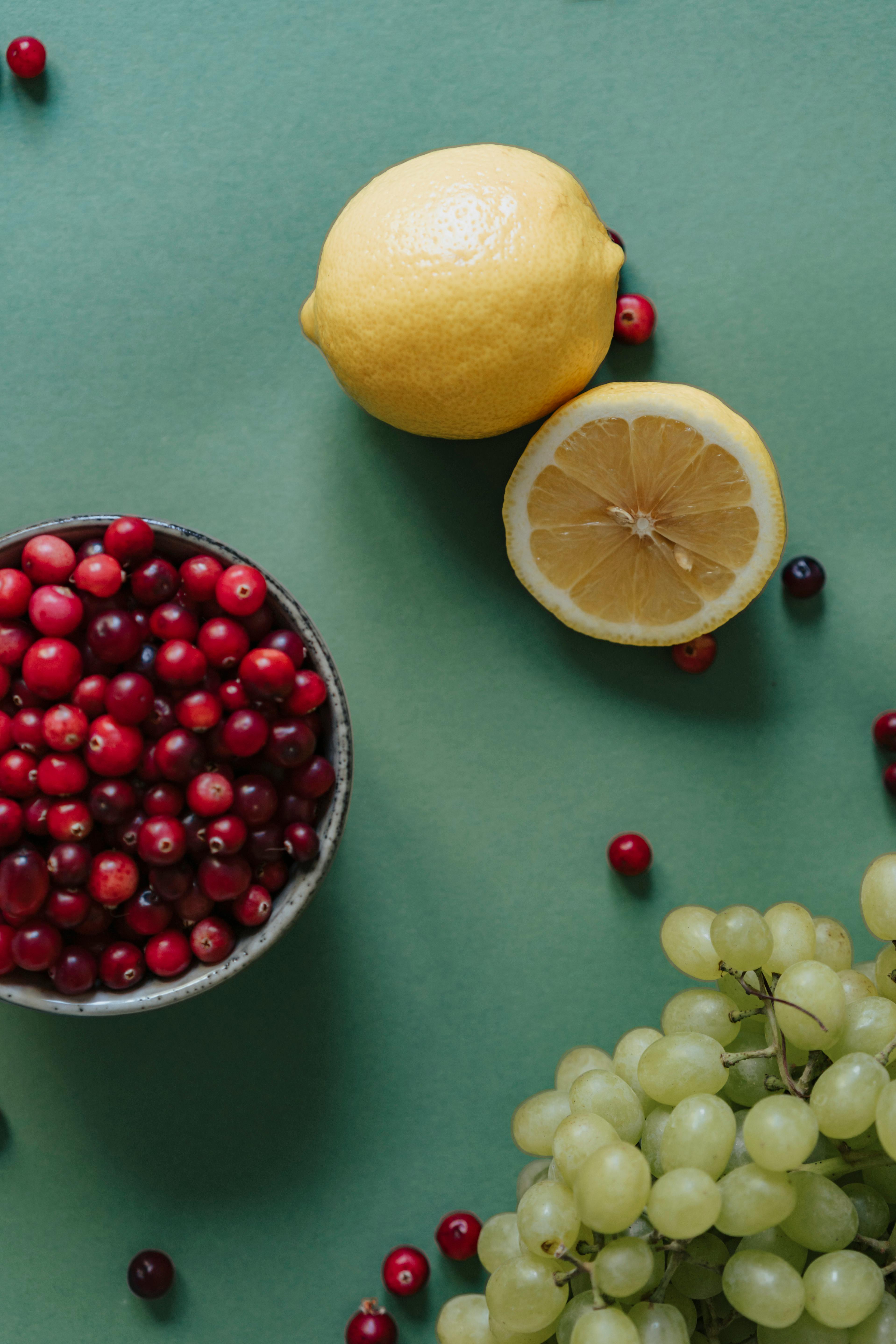 cranberries in abowl with sliced lemon and grapes