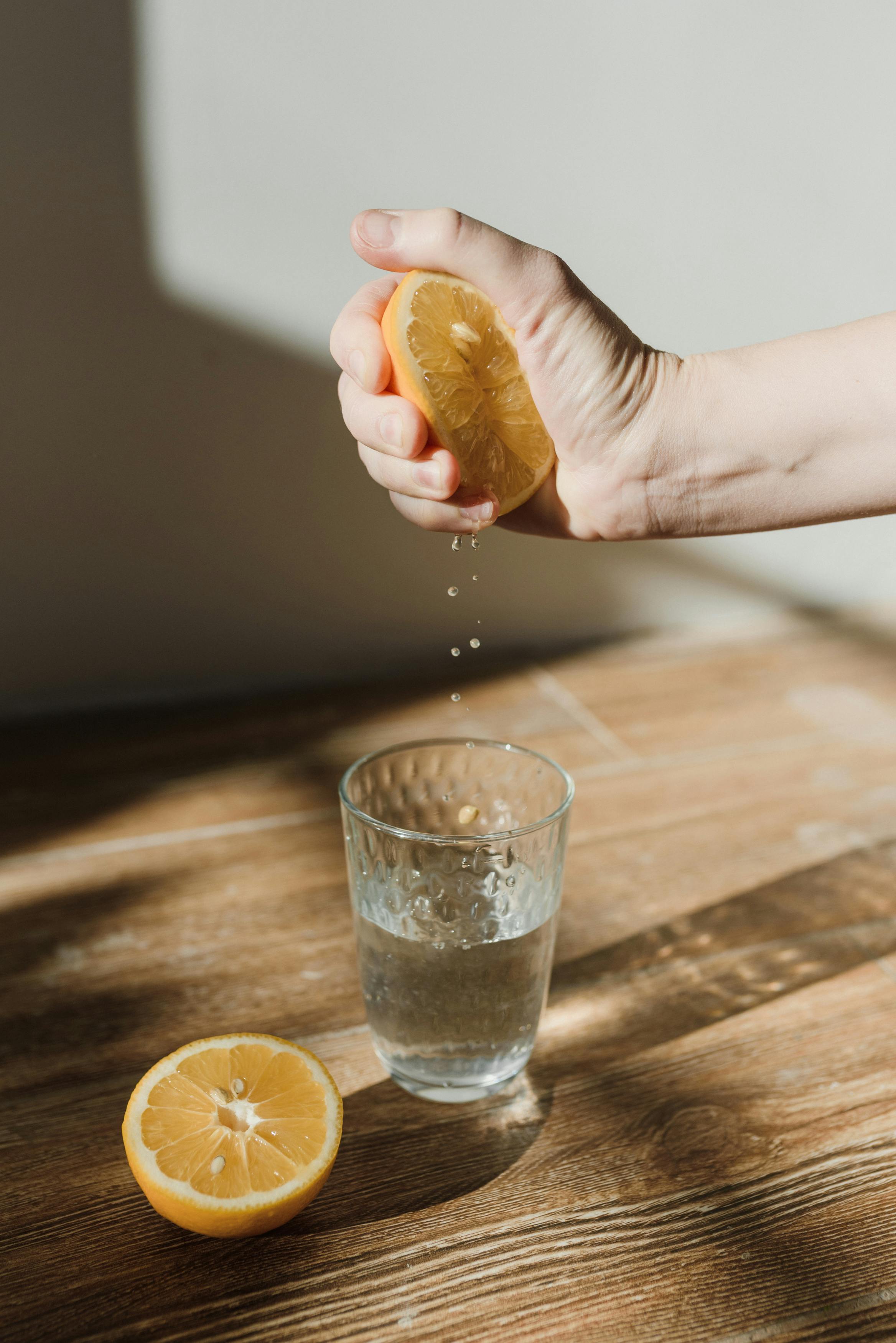 squeezing lemons into water squeezing lemons into water